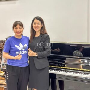 Nhân viên của Piano Đức Trí chụp hình cùng khách hàng mua đàn Yamaha U1J
