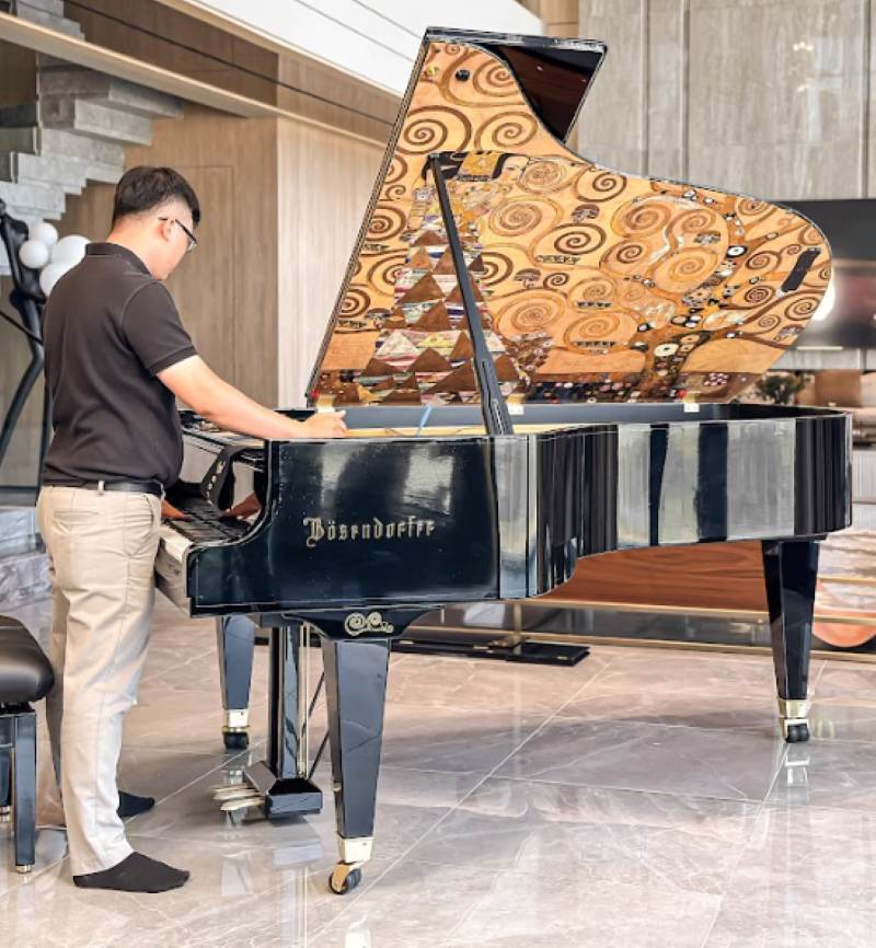 Hình ảnh nhân viên của Piano Đức Trí sửa đàn và bảo trì đàn piano tại nhà cho khách ở TPHCM