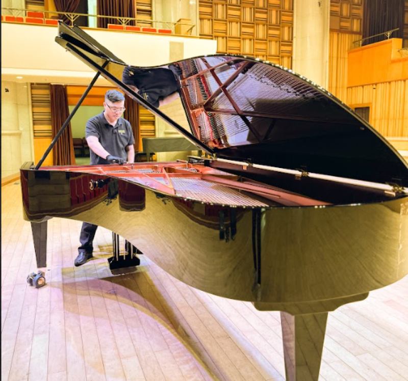 Nhân viên của Piano Đức Trí đang bảo trì đàn piano cơ cho khách tại nhà
